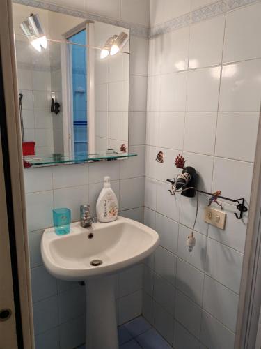 a white bathroom with a sink and a mirror at Casa PALLINA FIDENZA in Fidenza