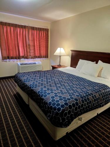 a hotel room with a bed and a window at Ashford Motel in Ashford