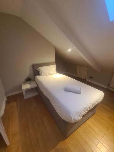 a bedroom with a large white bed in an attic at Coastal stay in South Shields