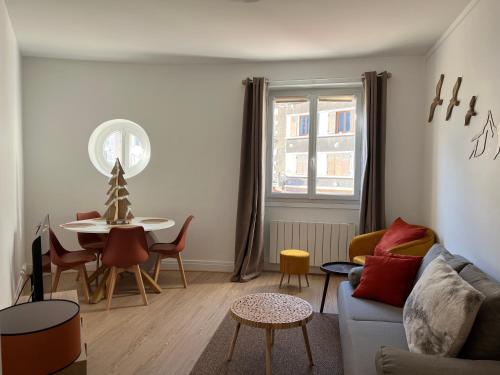una sala de estar con un sofá y una mesa en Guimbert'Home, en Le Bourg-dʼOisans