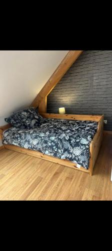 a bed with a wooden frame in a room at Maison vacance proche ste mère église in Picauville