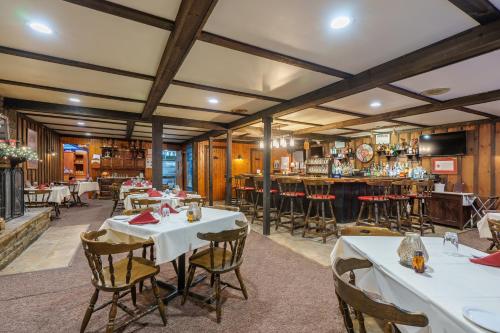 een eetkamer met tafels en een bar bij Cascade Inn in Lake Placid