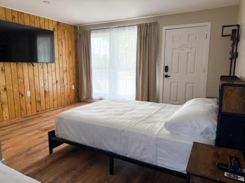 een slaapkamer met een bed en een flatscreen-tv bij Cascade Inn in Lake Placid