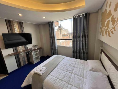 a bedroom with a large bed and a large window at Wary Nayra Hotel & Spa in Puno