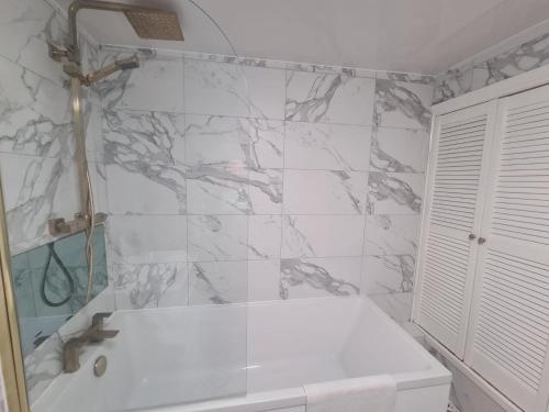 Stylish modern 2 bedroom apartment في سندرلاند: حمام مع دش وحوض استحمام أبيض