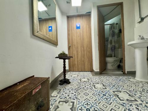 a hallway with a bathroom with a toilet and a door at Casa de la Cruz Centro Historico in Cartagena de Indias