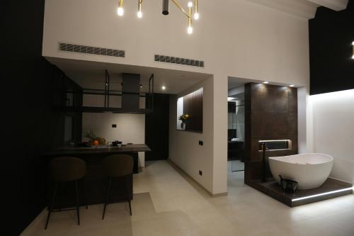 a bathroom with a tub and a kitchen with a table at Il Moro Luxury Rooms in Siracusa
