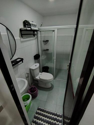 a small bathroom with a toilet and a shower at Central City Condo Getaway in Gun-ob