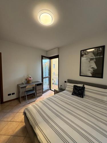 a bedroom with a bed and a table and a window at Appartamento Amendola in Luino