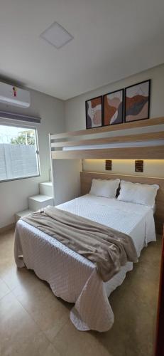 a bedroom with a large bed with white sheets at Cantinho Martins in Prado