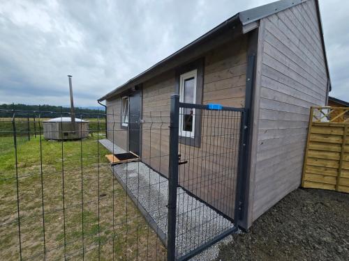 a chicken coop with a fence in a field at Domki Śnieżka in Wojcieszyce