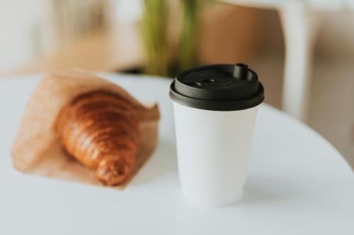 アウクスブルクにあるCandlewood Suites Augsburg by IHGの白いサーモスとクロワッサン