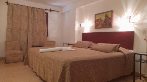 Un dormitorio con una cama grande con una manta marrón. en Toneles - Cafayate, en Cafayate