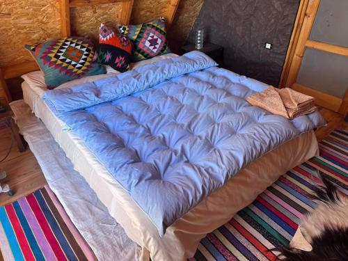 a large blue comforter on a bed in a room at Elhamma Resort Studio in Tozeur