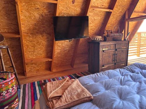 a bedroom with a bed and a flat screen tv at Elhamma Resort Studio in Tozeur