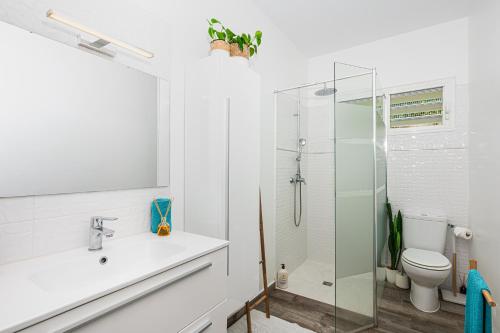 a white bathroom with a sink and a shower at La Kaz Zen - Cozy house with garden in Les Abymes