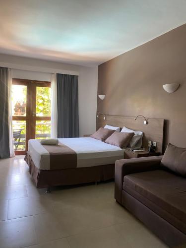 a bedroom with a large bed and a couch at Wind e Blue in Jericoacoara