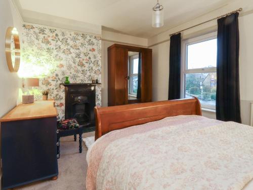 a bedroom with a bed and a desk and a fireplace at Levenside in Garstang