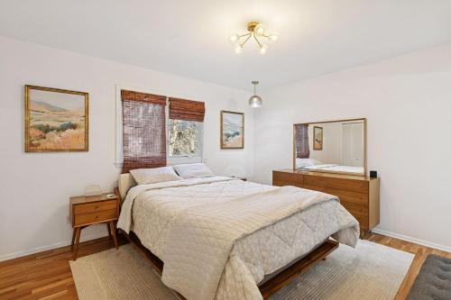 Modern Upper Unit, Hot Tub, Medicine Lake في مينيابوليس: غرفة نوم بها سرير كبير ومرآة