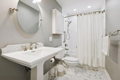 Modern Upper Unit, Hot Tub, Medicine Lake في مينيابوليس: حمام مع حوض ومرحاض ومرآة