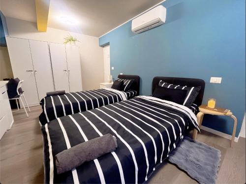 a bedroom with two beds and a blue wall at B&B Pizza Room Twin Room near Navigli Milan in Milan