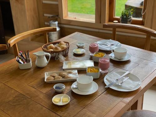 una mesa de madera cubierta con platos y tazones de comida en Hotel Boutique La Casa de Coco, en Gorbea