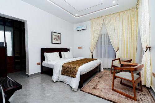 a bedroom with a bed and a chair in it at The Mason by Trovardig in Abuja