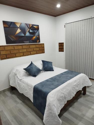 a bedroom with a large bed with blue pillows at Cabaña in Sáchica