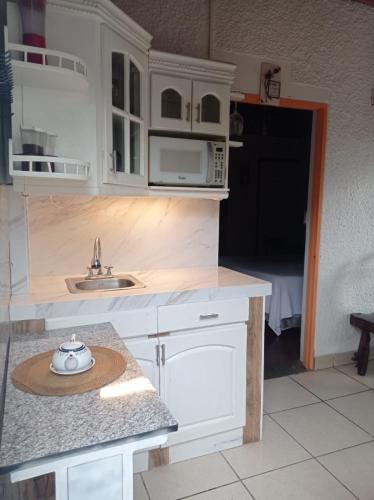 una cucina con mobili bianchi e un piano di lavoro di Cómodo Céntrico y Confortable a Managua
