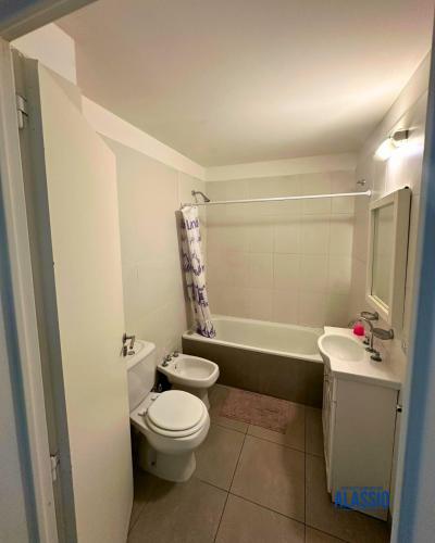 a bathroom with a toilet and a sink and a tub at Departamento Alassio in Tigre