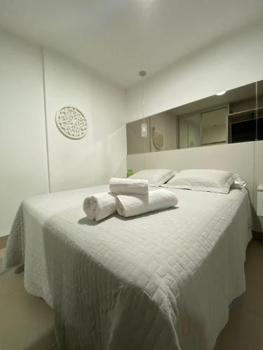 - une chambre blanche avec 2 serviettes blanches sur un lit dans l'établissement Studio moderno, à Uberlândia
