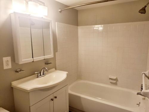 a bathroom with a sink and a tub and a mirror at Long term 1BR w Balcony & Parking Near Philly in Jenkintown