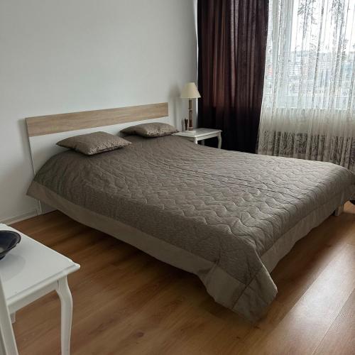 a bedroom with a bed and two tables and a window at Apartment in Prishtina, Kosovo in Pristina