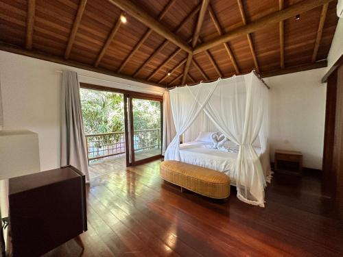 a bedroom with a bed with a mosquito net at Casa no Condomínio Aguas d'Ajuda in Porto Seguro