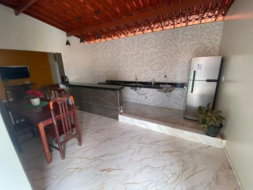 カモシンにあるApartamento aconchegoのテーブルと冷蔵庫のあるキッチン