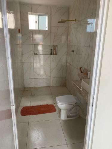 a bathroom with a shower and a toilet and a sink at Apartamento aconchego in Camocim