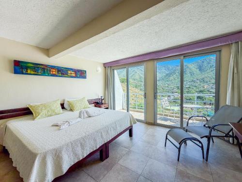 Hotel Bahia Taganga في تاجانجا: غرفة نوم بها سرير ونافذة كبيرة