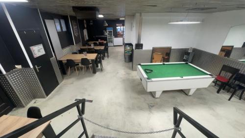 a pool table in a room with tables and chairs at GOOD NIGHT HÔTEL By L'excess in Vierzon