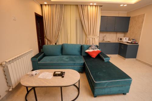 a living room with a green couch and a table at Rashha Suites Jhika Gali Murree in Murree