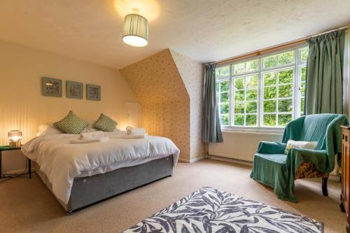 a bedroom with a bed and a window and a chair at Alderfen View by Leap Escapes in Worstead