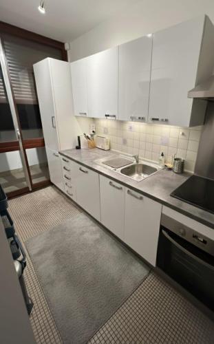 una cucina con mobili bianchi e un lavandino di Trocadero a Parigi
