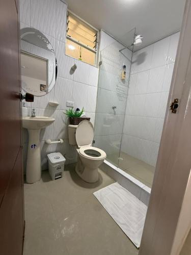 a bathroom with a toilet and a shower and a sink at Apartamento Limón Azul in Sogamoso