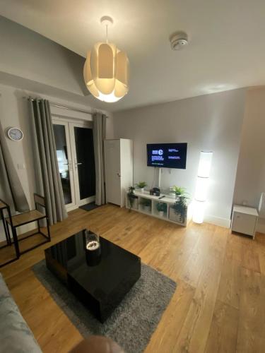 a living room with a black coffee table and a flat screen tv at Luxury home from home 2 in Maidstone
