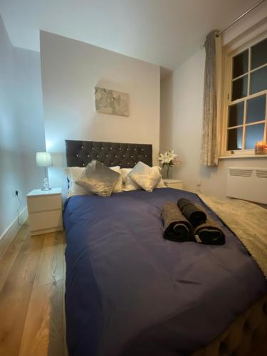 a bedroom with a large blue bed with two pillows at Luxury home from home 2 in Maidstone