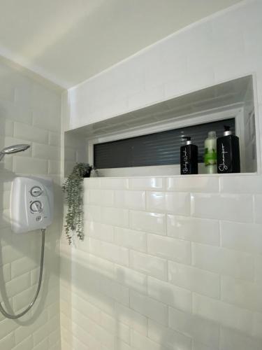 a bathroom with a shower with a white tile wall at Luxury home from home 2 in Maidstone