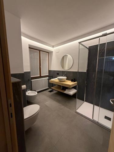 ein Badezimmer mit zwei Toiletten und einem Waschbecken und einer Dusche in der Unterkunft Curt di Manai Charme Apartments in Tirano