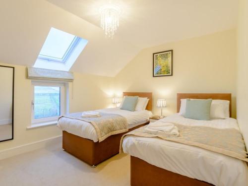 2 Bed in Alnwick oc-80488 في نيوتون باي ذا سي: سريرين في غرفة بها نافذة