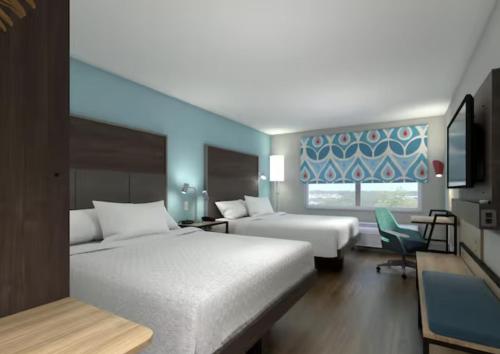 Tru By Hilton Puebla Angelopolis في بوبلا: غرفة فندق بها سريران ونافذة