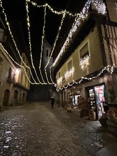 una calle vacía con luces de Navidad en un edificio en El Rincón Templario, en La Alberca