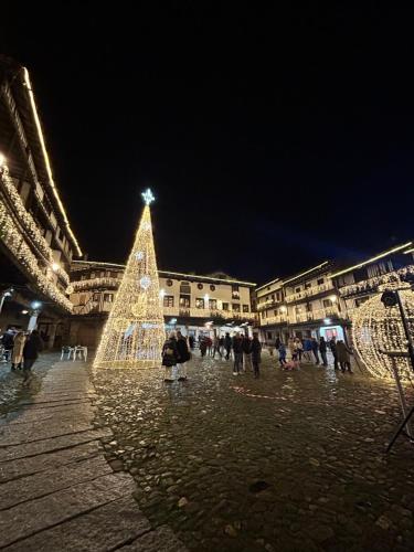 Un árbol de Navidad en medio de una plaza por la noche. en El Rincón Templario, en La Alberca